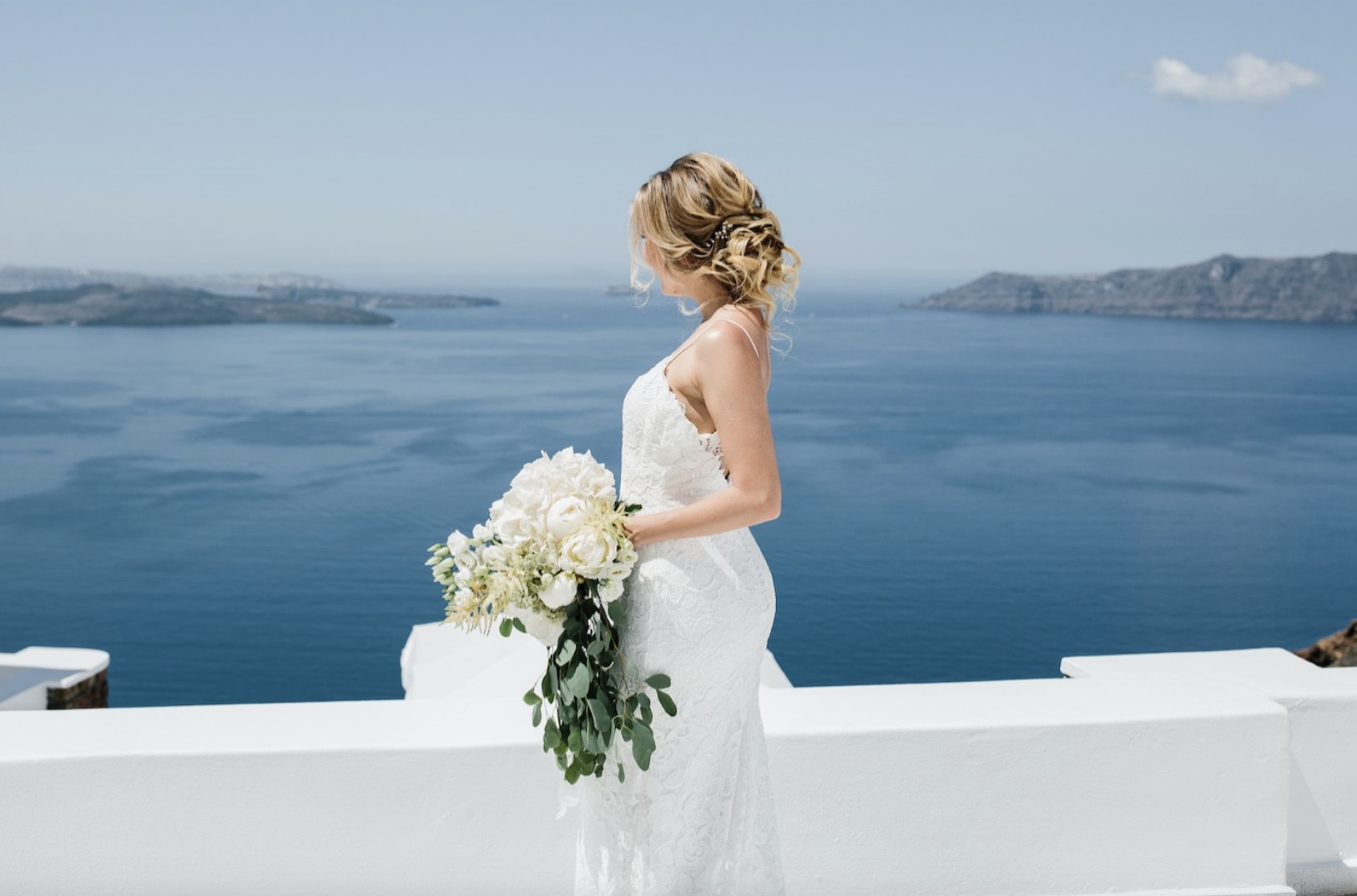 CAMILLA-KIRK-PHOTOGRAPHY-SANTORINI-MADI-LANE-BRIDAL-EMELIA-LACE-WEDDING-DRESS-WITH-SPLIT